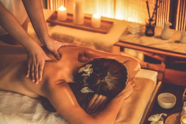 Beyaz kadın müşteri stres önleyici spa masajının keyfini çıkarıyor ve lüks otel ya da otelde sıcak mum ışığında güzellik teniyle eğleniyor. Sessiz.