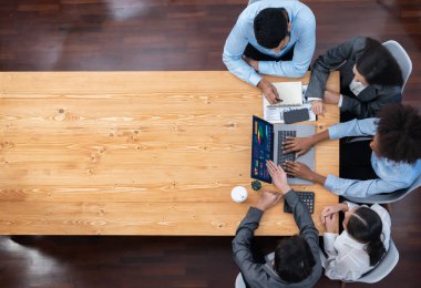 Panorama üst görüşlü çok ırklı analist ekibi, stratejik karar için finansal verileri analiz etmek amacıyla dizüstü bilgisayarda BI gösterge panelini kullanıyor. Fintech pazarlama göstergelerini analiz ediyor. Uyum