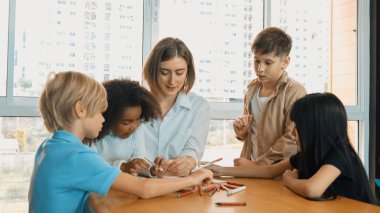 Masada masal kitabı ve renkli kitapla otururken çeşitli öğrencilere hikaye anlatan profesyonel beyaz bir öğretmen. Eğitmenden renkli resim alırken akıllı öğrenci dinlemeyi öğrenir. Etkinlik.