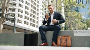 Kafkas iş adamları yeşil şehirde otururken tablet üzerinde çalışıyorlar. Uzman yönetici iş ekibiyle çalışırken finansal veri analizi yapmak ve aramak için tablet kullanıyor. Urbane.