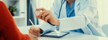 Hasta klinikte ya da hastane ofisinde doktor randevusuna gidiyor. Hastaların nabzını steteskopla kontrol ederken, doktor semptomları muayene ediyor ve teşhis ediyor. Panorama Katı