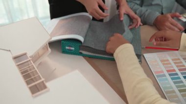Mimari ekipman kullanarak yavaş çekim ev tasarımcısı bir plan çizerken, iç mimari tasarımcı da müşterilerin talebine göre renk örneklerinden uygun renkler seçiyor. Değiştirilmiş