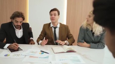 Çeşitli ofis çalışanları, işyerindeki iş sinerjisini ve üretken takım çalışmasını sembolize eden süslü ofis odasında el ele tutuşuyorlar. İş çalışanları arasındaki işbirliği ve birlik.