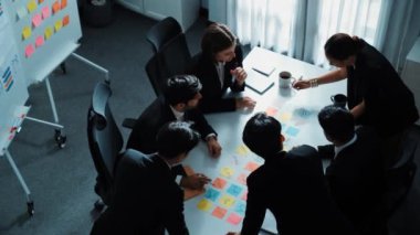 İş adamlarının toplantı odasında pazarlama stratejisi planlarken yapışkan notlar kullanarak beyin fırtınası yapma fikrine en iyi bakış açısı. Çeşitli takımlar mali planı tartışıyor. Takım çalışması konsepti. Müdürlük.