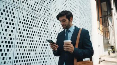 Akıllı iş adamı iş yatırımları hakkında konuşmak için telefonu kullanıyor. İş planı, pazarlama stratejisi ya da çalışma hakkında konuşmak için akıllı telefonla konuşurken sokakta yürüyen mutlu bir yönetici. Sevinçli..