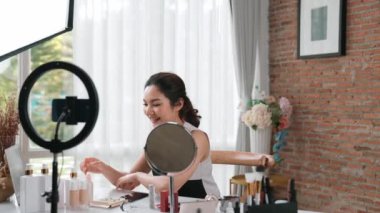 Kadın nüfuzlu kişi sosyal medya ya da blog için canlı yayın yapan video klip eleştirmeni derisini çekiyor. Canlı kozmetik stüdyosu ışıklandırması olan mutlu genç bir kız pazarlama için internet üzerinden yayın yapıyor..