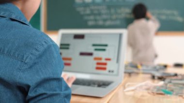 Kız, yazılım geliştirme planı yazarken yapay zeka yazılımı ya da programlama sistemini kullanarak kök sınıftaki elektronik ana tahtada yapay zeka üretiyor. Pedagoji.