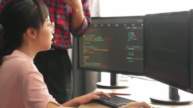 Yavaş çekimde geri uç veya yazılım geliştirici yöneticisi ekibini monitörde hata ayıklama ve karmaşık kod algoritmalarını çözmede yeni uygulama programı geliştirmede denetliyor. Filizlenen