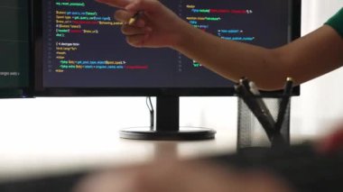 Yavaş çekim arkası yazılım geliştirici mühendisi bilgisayar programlama için birlikte çalışarak hata ayıklama kodunu çözüyor, ofiste monitörde karmaşık algoritmaları çözüyor. Filizlenen