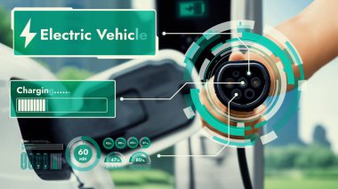 Kameranın önündeki EV şarj aletine odaklan. Akıllı dijital batarya durum hologramını göster. İş adamı eli de bulanık ESG yeşil şehir manzaralı olsun. Elektrikli araba şarjı temiz enerji kullanır. İnceleyin
