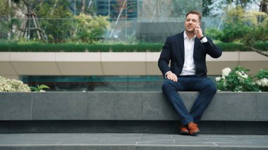 Kafkas işadamı, yatırımcılarla pazarlama stratejisi hakkında konuşurken parkta oturuyor. Mutlu akıllı yönetici, artan satışlar ya da Eko City 'de başarılı bir proje arıyor. Yaşam tarzı. Urbane