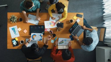 Becerikli iş adamlarının pazarlama fikrine ilişkin üst düzey bir görüş, bir grup yatırımcı hisse senedi borsası grafiği veya veri analiz belgesine bakarken dinleme ve planlama stratejisi sunarken ortaya atıldı. Cemaat.