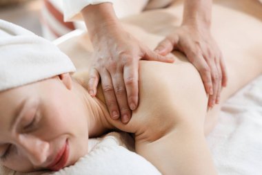 Güzel genç bir kadın, profesyonel masözden kaplıca yatağına sırt masajı almış. Çekici kadın masaj terapistinin yetenekli elleriyle rahatlıyor. Doğayla çevrili. Huzur.