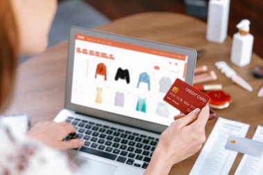 İnternet pazarından alışveriş yapan kadın modern yaşam tarzı için satış malzemeleri arıyor ve son derece siber güvenlik yazılımı tarafından korunan cüzdandan çevrimiçi ödeme için kredi kartı kullanıyor