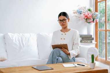 Klinikteki psikolog kadın. Profesyonel portresi. Dostane gülümsemesiyle hastayı psikoloğa davet ediyor. Tecrübeli ve kendinden emin psikolog en iyi uzmandır.