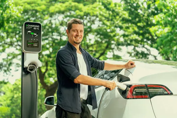 Mann Lädt Batterie Für Elektroauto Während Der Fahrt Elektroauto Naturwald — Stockfoto