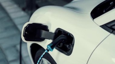 Şarj istasyonundan çevre dostu araba şarj oluyor. Fütürist hologram görüntü bataryası durumu. Alternatif enerji teknolojisinde son gelişmeler ve şarj edilebilir EV araba. İnceleyin