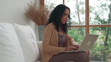 İnternette önemli bir iş için dizüstü bilgisayar kullanan Afro-Amerikalı bir kadın. Evde çalışan sekreter veya çevrimiçi içerik yazma.