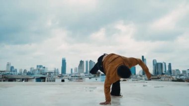 B-boy dans gösterisi çatıda sokak dansçısı ve gökyüzü dövüşçüsü, şehir manzaralı. Çekici Asyalı hipster enerjik adımlar atıyor. Break dansçı sokak dansı. Açık hava sporu 2024 hiphop..