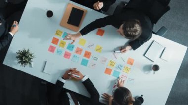 Profesyonel iş adamlarının yukarıdan aşağı görüşü, yönetici müdürüyle beyin fırtınası yaparken yapışkan notlar kullanarak çözüm buluyor. Çeşitli başlangıç takımları pazarlama stratejisini paylaşıyor. Müdürlük.