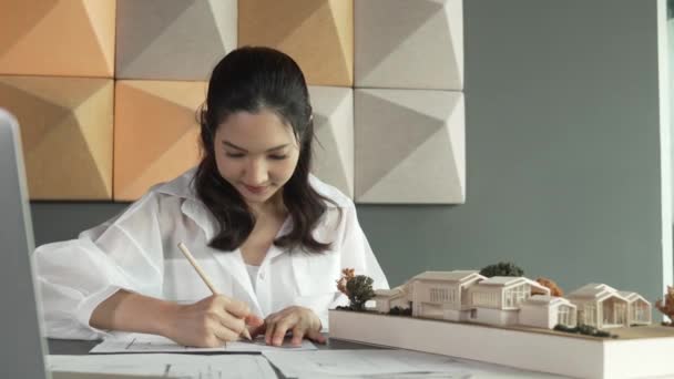 아름다운 건축가 엔지니어의 초상화는 노트북 프로젝트 청사진이 테이블에 청사진에 메모를하는 — 비디오