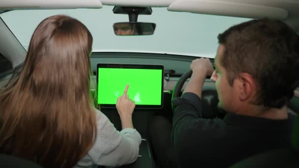 環境にやさしい車のコンセプトで休暇旅行 Ev電池の状態のための空白のコピースペースの緑のスクリーンの車のモニターを握る運転者の座席の環境に配慮した若いカップル エクスアルト — ストック動画
