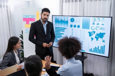 Pazarlama stratejisi için modern toplantıda veri analizi paneli ekranında sunan bir işadamı. Bir grup iş adamıyla konferans odasında iş sunumu. Uyum