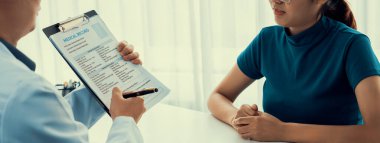 Klinikteki ya da hastane ofisindeki doktor randevusuna katılan hasta, tıbbi tedavi seçeneklerini tartışıyor ve muayene sonuçlarını ya da hastalıkla ilgili tıbbi kayıtları açıklıyor. Panorama Katı