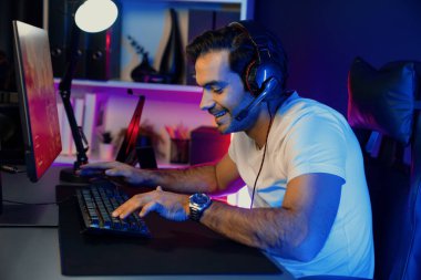 Akıllı oyun flaması dijital neon ışıklı siber odada kulaklık takarak bilgisayar ekranında çoklu ya da tek oyuncuyla çevrimiçi atış oyunu oynayan bir savaş takımı ile oynamaktan zevk alır. Tahmin et..