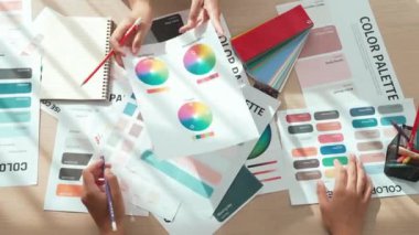 Üst görünüm yavaş çekim eli, grafik tasarımı için çalışan iki tasarımcının ya da tasarımcıdan yaratıcı kromatik konsültasyonda renk uygulaması arayan istemcinin masasının üzerinde. Değiştirilmiş