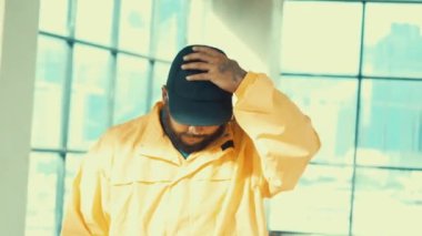 Mutlu Asyalı hipster pozu ve bina kameralarına gülümseme. Kameraya gülümseyen yetenekli sokak dansçılarının yakın çekimi. Parlak ışık. Sokak dansı adımları. Açık hava sporu 2024 hiphop..