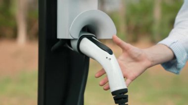 Otomobil seyahati sırasında elektrikli araba için şarj olan kadın Autumanl sezonunda doğal orman ya da milli parkta. Tatil ve tatil boyunca çevre dostu seyahat. Yükselt