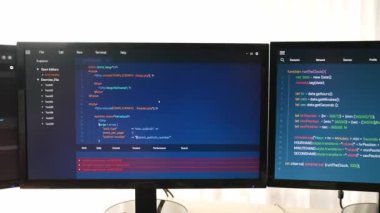 Yavaş çekim arkası yazılım geliştirici mühendisi bilgisayar programlama için birlikte çalışarak hata ayıklama kodunu çözüyor, ofiste monitörde karmaşık algoritmaları çözüyor. Filizlenen