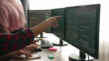 Yavaş çekim arkası yazılım geliştirici mühendisi bilgisayar programlama için birlikte çalışarak hata ayıklama kodunu çözüyor, ofiste monitörde karmaşık algoritmaları çözüyor. Filizlenen