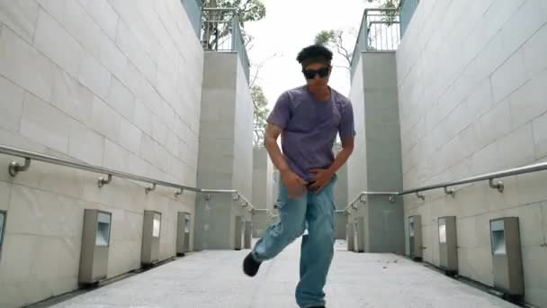专业的霹雳舞蹈演员在狭窄的走廊表演街头舞蹈 熟练的快乐的亚洲嬉皮士走向音乐 同时在狭窄的墙壁上展示B Boy步法 现代生活方式 2024年户外运动 神气活现 — 图库视频影像