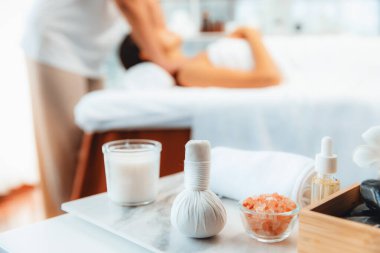 Aromaterapi masajı gündüz atmosferinde ya da spa salonunda bulanık bir kadına odak dekor ve spa aksesuarları kurarak tatil köyünde ya da otel arka planında keyifli aroma spa masajı yapan bir masaj. Sessiz.