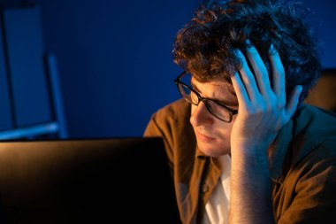 Stresli yaratıcı yönetici yeni sunumla tasarım araması yaparken ev ofisteki dizüstü bilgisayarlı ekranda gece vakti neon lambalı bir odada e-posta göndermeyi bekliyor. Toplayıcı.