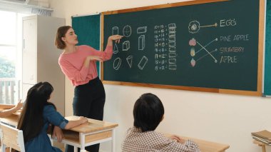 Zeki öğretmen sınıfta fikri açıklarken sevimli öğrenci ödevlerini kontrol ediyor. Not defterine bakıp matematik teorisinden çocuğa bahsederken sınıfta dolaşan çekici bir eğitmen. Pedagoji.