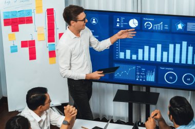 Ofiste sunum ya da analist ekibiyle toplantı odasında mali verileri analiz etmek için BI Fintech 'i kullanmak. İş adamları stratejik planlama için TV ekranında BI gösterge panelini inceliyor.