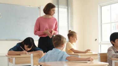 Enerjik zeki öğretmen sınıftaki beyaz çocuğa sınıf çalışmasını anlatırken aynı zamanda çok kültürlü bir öğrencinin derste dinlemesini ve çalışmasını anlatıyor. Aktif öğretmen sınav ya da sınıf çalışmasından bahsediyor. Pedagoji.