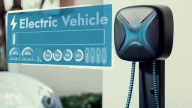 Elektrikli araba, gelecekteki ev şarj istasyonunda akıllı dijital EV batarya durumu hologramıyla şarj oluyor. EV arabasının teknolojik gelişimi ve sürdürülebilir gelecek için ev enerjisi altyapısı. İncelenme