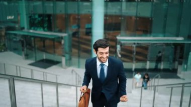 Terfi alma, satışları artırma, maaşları artırma konusunda iyi haberleri kutlamak için dans eden mutlu iş adamı şehirde geçmişi bulanık bir şekilde merdivenlerden çıkarken. Neşeli bir ruh hali. Sevinçli..