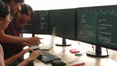 Yavaş çekim arkası yazılım geliştirici mühendisi bilgisayar programlama için birlikte çalışarak hata ayıklama kodunu çözüyor, ofiste monitörde karmaşık algoritmaları çözüyor. Filizlenen
