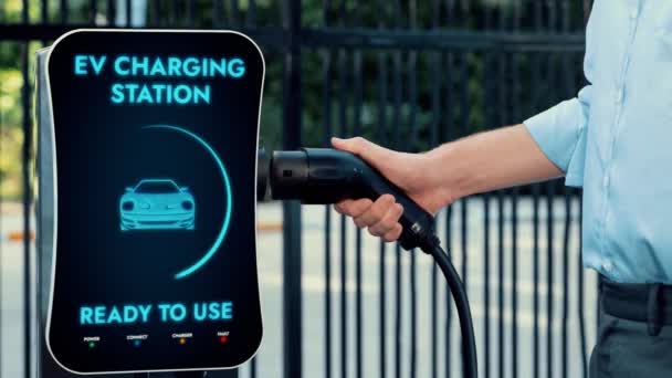 商人把电动汽车充电器从收费站拉出来 在市区停车场给电动汽车充电 利用现代城市生活方式和环保电动汽车减少二氧化碳的排放 — 图库视频影像