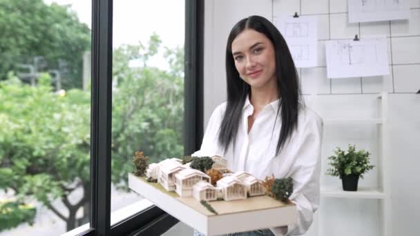Schöne Junge Kaukasische Architektin Zeigt Hausmodell Stehen Und Lächelt Selbstbewusst — Stockvideo