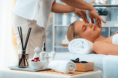 Kafkasyalı kadın stres önleyici kafa masajından ve lüks tatil beldesi ya da otel spa salonundaki modern ışık ortamında yüz güzelliği eğlencelerini şımartmaktan hoşlanıyor. Sessiz.