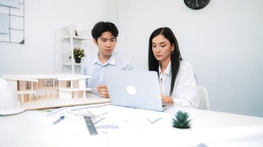 Profesyonel erkek mühendis ev modelini cetvel kullanarak ölçerken güzel bir kooperatif iş arkadaşı verileri analiz etmek için dizüstü bilgisayar kullanarak birlikte çalışıyor. Yaratıcı tasarım ve takım çalışması. - Yakın çekim. Tertemiz..