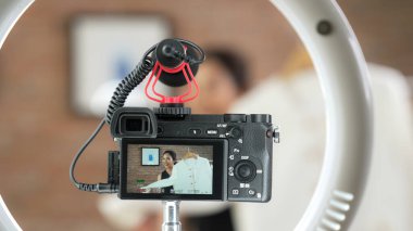 Arka görünüm, kamera ekranında kadın nüfuzunu gizler. Video görüntüleme, video görüntüleme, giysi, sosyal medya ya da blog. Canlı yayın için canlı stüdyo ışıklandırması olan kız canlı yayın pazarlama kaydı