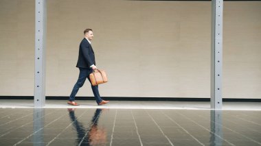 İş adamlarının bavul tutarken ve şehir merkezindeki iş yerine yürürken yan görüntüsü. Profesyonel proje yöneticisi dışarıda resmi takım elbise giyerken toplantıya gidiyor. Urbane.