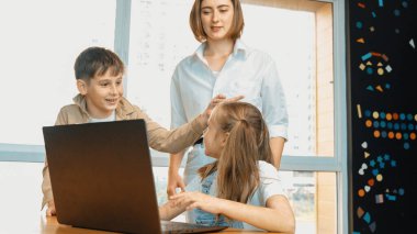 Zeki beyaz öğrenci, öğretmen ekrana bakıp programı kontrol ederken dizüstü bilgisayar yazma kodunu kullanıyor. Profesyonel eğitmen BTMM sınıfında programlama sistemini öğrenmeye yardım ediyor. Etkinlik.